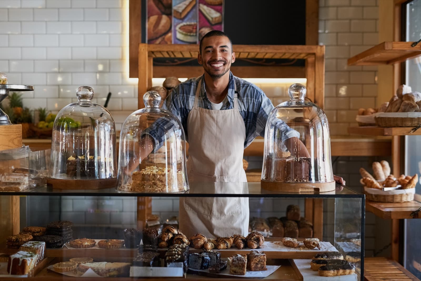 Smiling bakery owner standing behind a pastry counter
