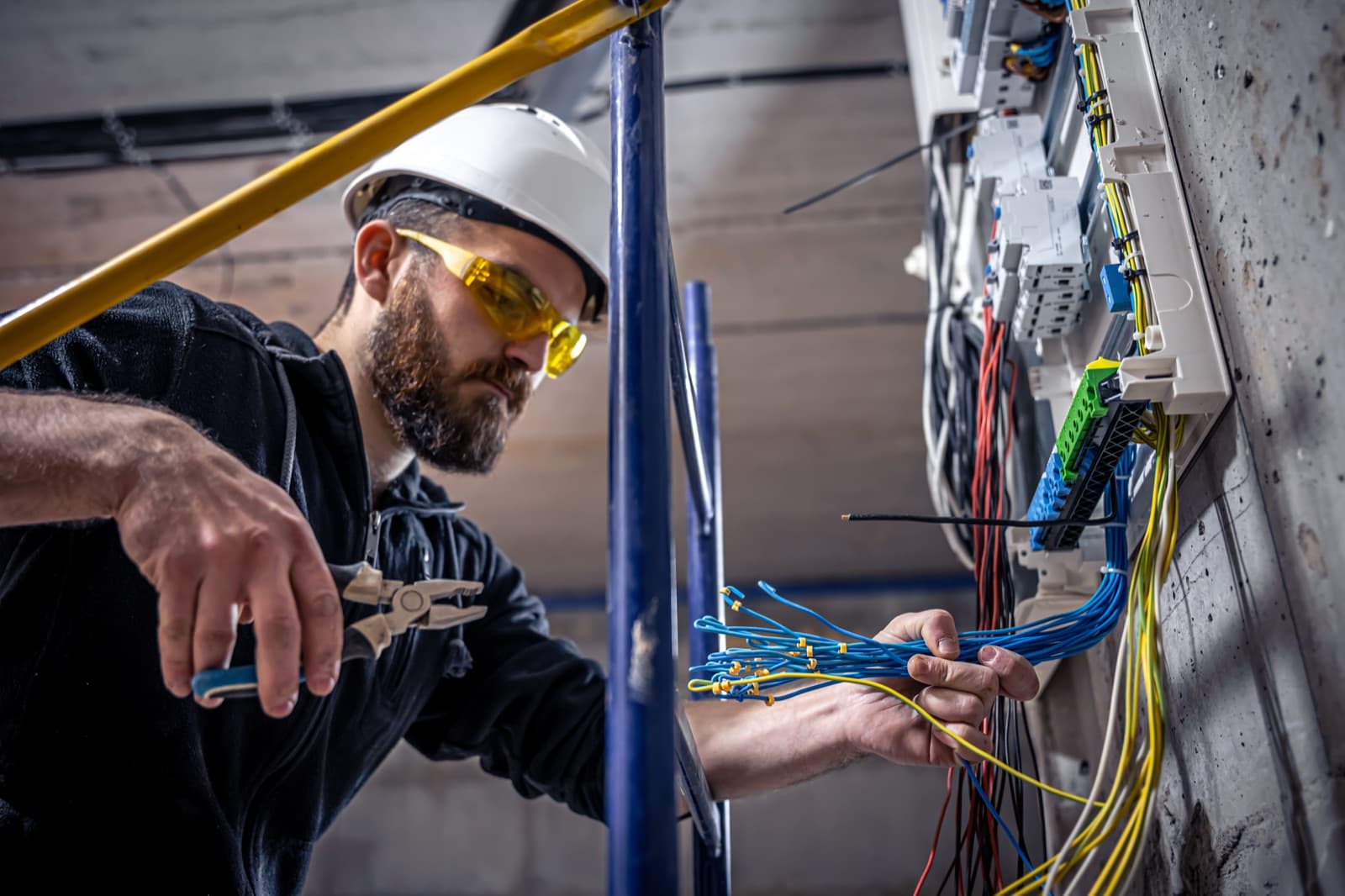 Licensed electrician working inside a commercial switchboard