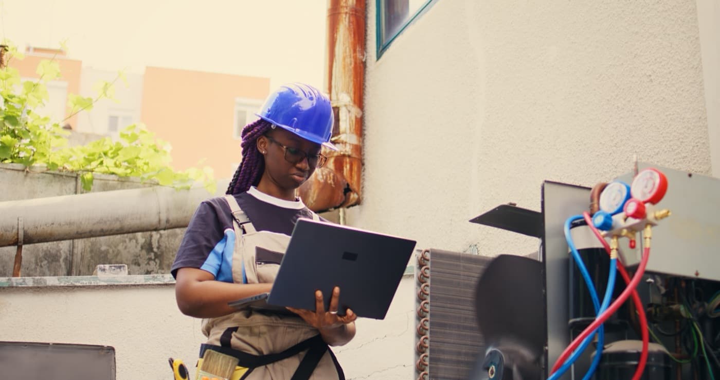 HVAC technician inspecting an outdoor air-conditioning system