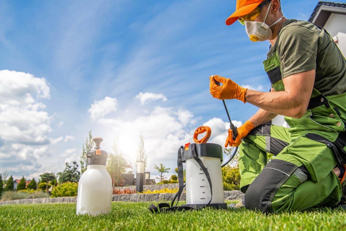 Pest-control technician preparing outdoor treatment equipment