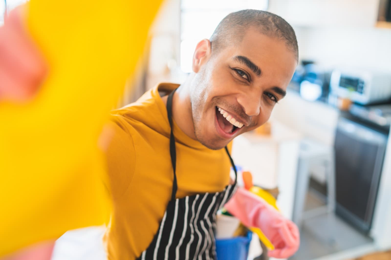 Smiling cleaner working in a residential kitchen